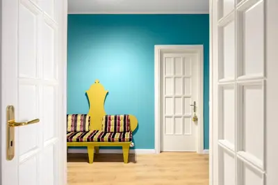 a room with a yellow chair and a blue wall at Verosicily Sant'Elia suite in Palermo