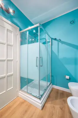 a glass shower in a bathroom with blue walls at Verosicily Sant'Elia suite in Palermo