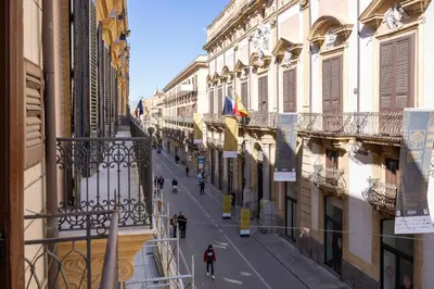 a city street with buildings and people walking down the street at Verosicily Sant'Elia suite in Palermo