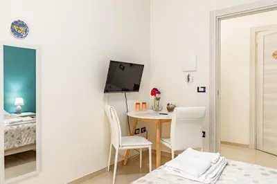 a small room with a table and chairs and a bed at Sicily Trinacria House in Palermo