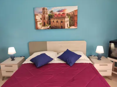 a bedroom with a large bed with two night stands at Sicily Trinacria House in Palermo