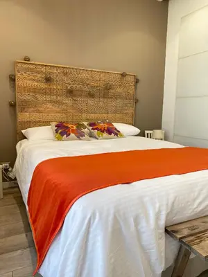 a bedroom with a large bed with an orange blanket at Dimora D'aumale in Palermo
