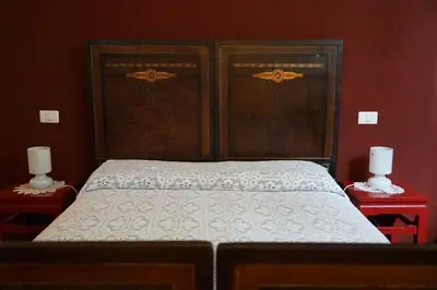 a bed in a red room with two red tables at Casa Professa Luxury Palermo Center in Palermo