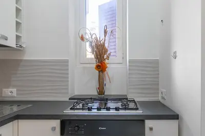 a vase of flowers sitting on a stove in a kitchen at GuestHost - Ballarò Market Cozy Apartments in Palermo