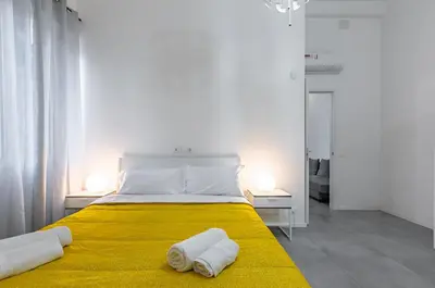 a bedroom with a yellow bed with towels on it at GuestHost - Ballarò Market Cozy Apartments in Palermo