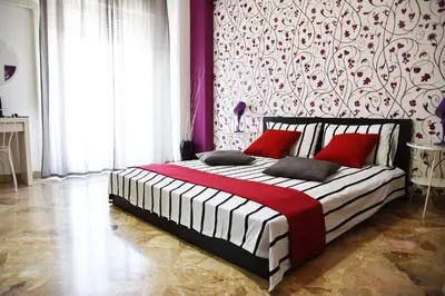 a bedroom with a large bed with red pillows at Papillon BnB in Palermo