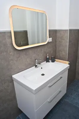 a bathroom with a white sink and a mirror at Papillon BnB in Palermo