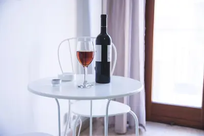 a bottle of wine sitting on a table with a glass at Papillon BnB in Palermo