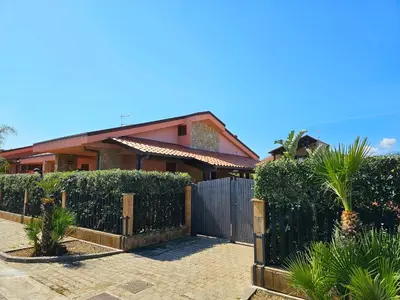 a house with a fence in front of it at Costa Mediterranea Holiday Homes in Campofelice di Roccella