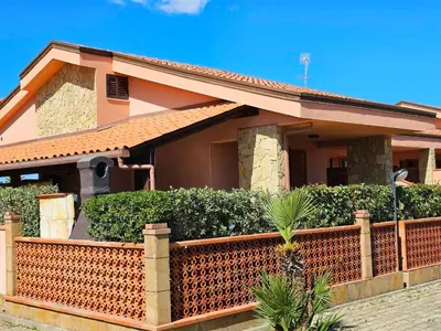 a house with a fence in front of it at Costa Mediterranea Holiday Homes in Campofelice di Roccella