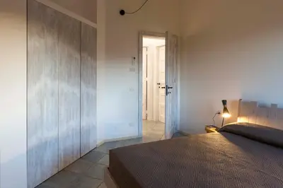 a bedroom with a bed and a door to a hallway at Villa Corallo Cala Bianca in Castellammare del Golfo