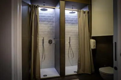a shower with a glass door in a bathroom at Hostelò - Luxury Hostel in Palermo