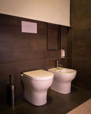 a bathroom with a toilet and a sink at Hostelò - Luxury Hostel in Palermo