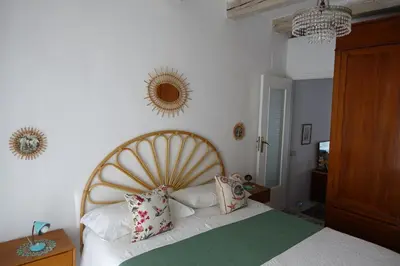 a bedroom with a white bed with a wooden headboard at Casa Vacanze Flavia in Palermo