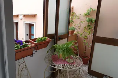 a balcony with potted plants and a table and a mirror at Casa Vacanze Flavia in Palermo