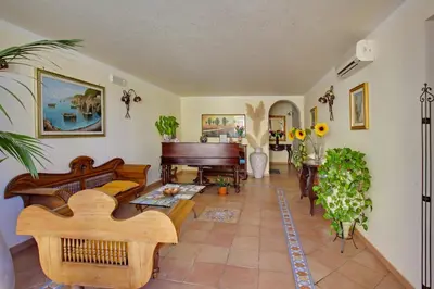 a living room filled with furniture and a piano at Kalura B&B in Macari