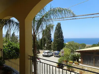 a balcony with a view of a parking lot and the ocean at Kalura B&B in Macari