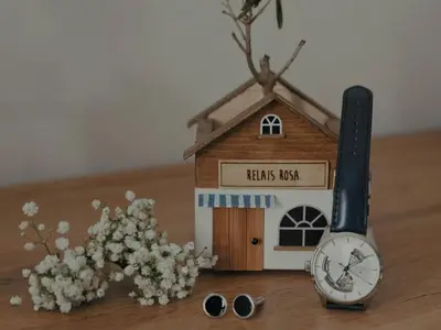 a small house with a clock and flowers on a table at Relais Rosa Apartment in Palermo