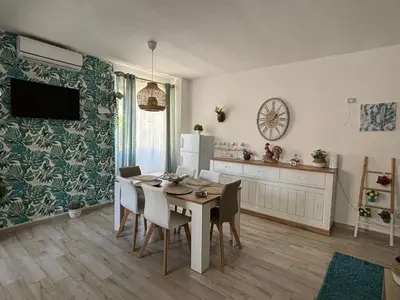 a kitchen and dining room with a table and chairs at Relais Rosa Apartment in Palermo