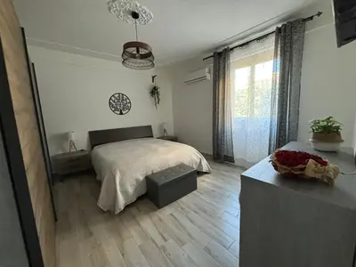 a bedroom with a bed and a large window at Relais Rosa Apartment in Palermo