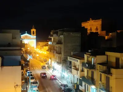 a city street at night with buildings and street lights at La Rondine Bed in Ficarazzi