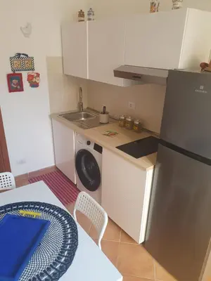 a small kitchen with a sink and a refrigerator at La Casetta del piano di sopra in Palermo