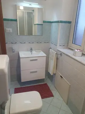a bathroom with a sink and a toilet and a mirror at La Casetta del piano di sopra in Palermo