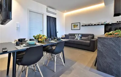 a kitchen and living room with a table and chairs at 2 Bedroom Awesome Apartment In Trappeto in Trappeto