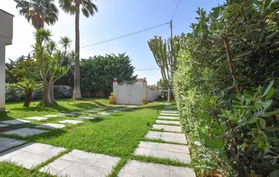 a garden path with grass and trees in a yard at 2 Bedroom Awesome Apartment In Trappeto in Trappeto