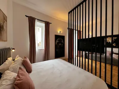 a bedroom with a large white bed and a staircase at Giglio luxury apartment in casa professa in Palermo