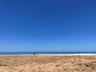 a sandy beach with people walking in the ocean at Holiday Home Perla by Interhome in Partinico