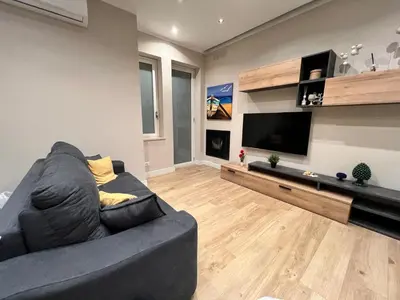 a living room with a couch and a flat screen tv at Florio House in Palermo