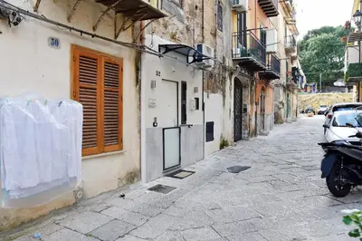 an alley with a motorcycle parked next to a building at Ó sole mio in Palermo
