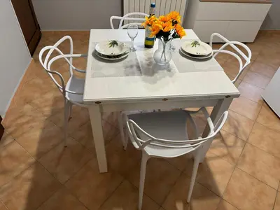 a white table with chairs and a vase of flowers on it at Casa del mare Mely in Ficarazzi