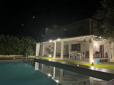 a house with a swimming pool at night at Villa sole Sicily in Terrasini