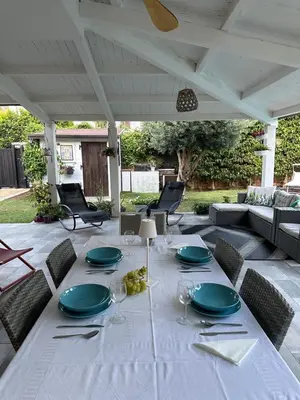 a white table with plates and wine glasses on a patio at Villa sole Sicily in Terrasini