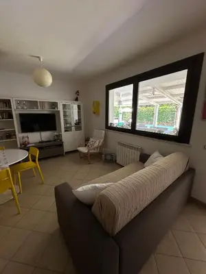 a living room with a couch and a large window at Villa sole Sicily in Terrasini