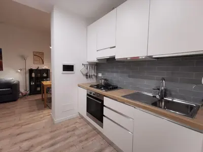 a kitchen with white cabinets and a sink and a stove at Casarino House Luxury Apartment in Palermo