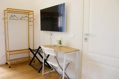 a room with a table and a television on a wall at Valverde Home in Palermo
