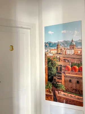 a picture hanging on a wall next to a door at Aristocasa luxury rooms in Palermo