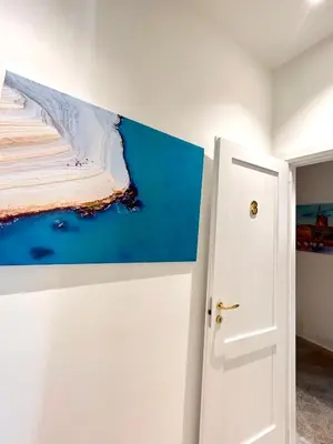 a painting on a wall next to a door at Aristocasa luxury rooms in Palermo