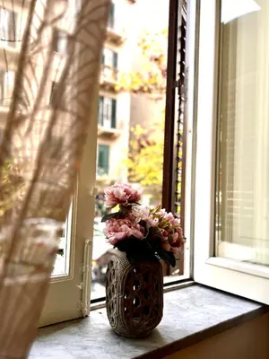 a vase filled with flowers sitting on a window sill at Aristocasa luxury rooms in Palermo