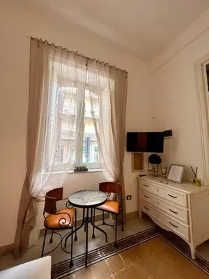 a room with a table and chairs and a window at Aristocasa luxury rooms in Palermo