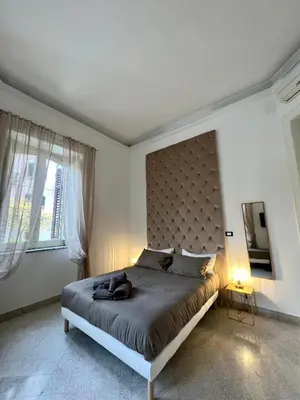 a bedroom with a large bed with a large headboard at Aristocasa luxury rooms in Palermo