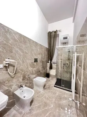a bathroom with a toilet and a shower and a sink at Aristocasa luxury rooms in Palermo
