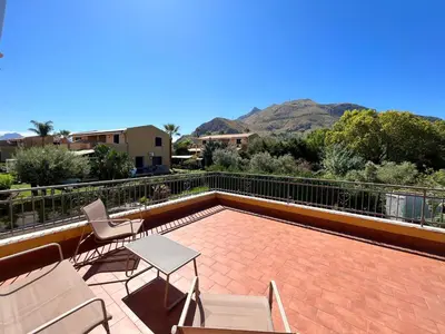 a patio with a table and chairs on a roof at Villa CLARA in Altavilla Milicia
