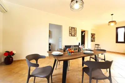 a dining room with a wooden table and chairs at Villa CLARA in Altavilla Milicia