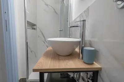 a bathroom with a white bowl sink on a wooden table at Il Cortile Isola Casa Vacanze in Isola delle Femmine