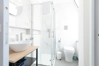 a white bathroom with a sink and a toilet at Il Cortile Isola Casa Vacanze in Isola delle Femmine