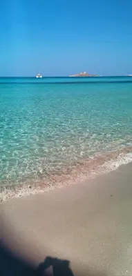 a shadow of a person taking a picture of the ocean at Il Cortile Isola Casa Vacanze in Isola delle Femmine